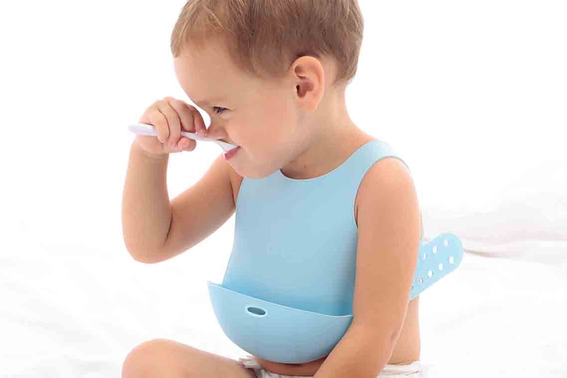 Minikoioi – śliniak silikonowy z kieszonką i zapięciem na plecach Niebieski